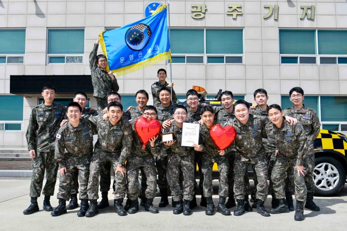 공군1전투비행단 운항관제대 장병들이 송민준(앞줄 가운데) 일병의 조혈모세포 기증을 축하하며 기념촬영을 하고 있다. 사진 제공=윤민우 병장