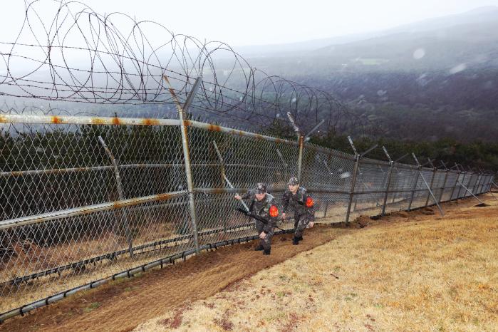 해군기동함대 268해상감시장비운용대에서 병사들이 기지 경계철책을 따라 이동하며 순찰하고 있다.