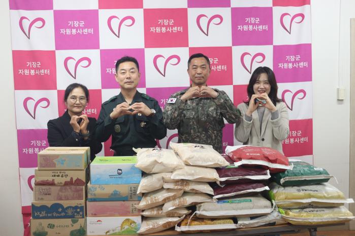 한재관(오른쪽 둘째) 육군53보병사단 부산여단 주임원사와 유주흥(왼쪽 둘째) 기장군 기동대장이 기장군 자원봉사센터에 물품을 기부하며 기념사진을 찍고 있다. 부대 제공