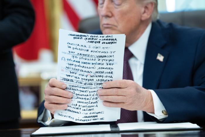 도널드 트럼프 미국 대통령이 지난달 31일(현지시간) 워싱턴DC 백악관 집무실에서 우편 투표 규정을 강화하는 행정명령에 서명하기 전 서류를 들어 정리하고 있다. 트럼프는 서명식 행사에서 이란에 대한 군사 작전을 2~3주 안에 종료할 수 있다고 말했다. EPA·연합뉴스