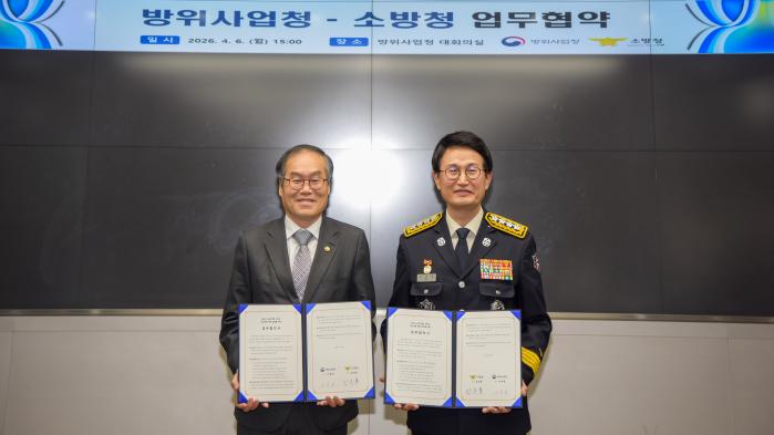 이용철(왼쪽) 방위사업청장과 김승룡 소방청장이 6일 정부과천청사에서 민·군 소방 역량 강화를 위한 업무협약서에 서명한 뒤 협약서를 들어보이고 있다. 방사청 제공