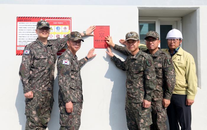 이충희(왼쪽 둘째) 수도포병여단장을 비롯한 지휘부가 수송부 건물에 안전 가디언 보드와 레드존 표지를 부착한 뒤 기념촬영하고 있다.