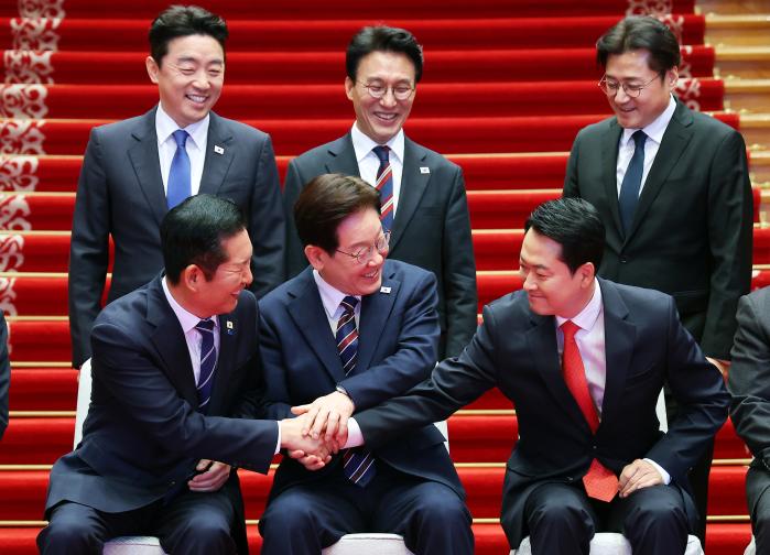 이재명 대통령이 7일 청와대에서 ‘여·야·정 민생경제 협의체’ 회담에 앞서 기념촬영 중 더불어민주당 정청래(앞줄 왼쪽) 대표, 국민의힘 장동혁(앞줄 오른쪽) 대표와 손을 잡고 있다. 뒷줄은 왼쪽부터 강훈식 대통령비서실장, 김민석 국무총리, 홍익표 정무수석. 연합뉴스