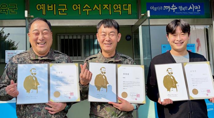 육군31보병사단 이순신여단 여수시 예비군지역대 군무원들이 대한적십자사로부터 받은 헌혈유공장을 들고 기념촬영을 하고 있다. 부대 제공