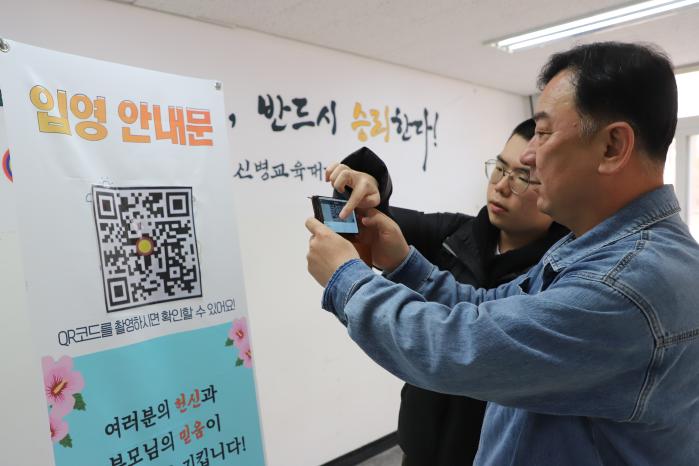 육군15보병사단 신병교육대대 입영을 앞둔 입영장정과 부모님이 QR코드를 통해 안내장을 확인하고 있다. 부대 제공