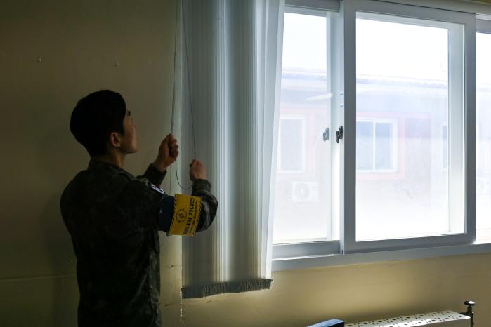 공군3미사일방어여단 장병이 일상 속 에너지 절약 대책의 하나로 시행 중인 ‘프리라이트 타임’에 블라인드를 걷고 있다. 부대 제공