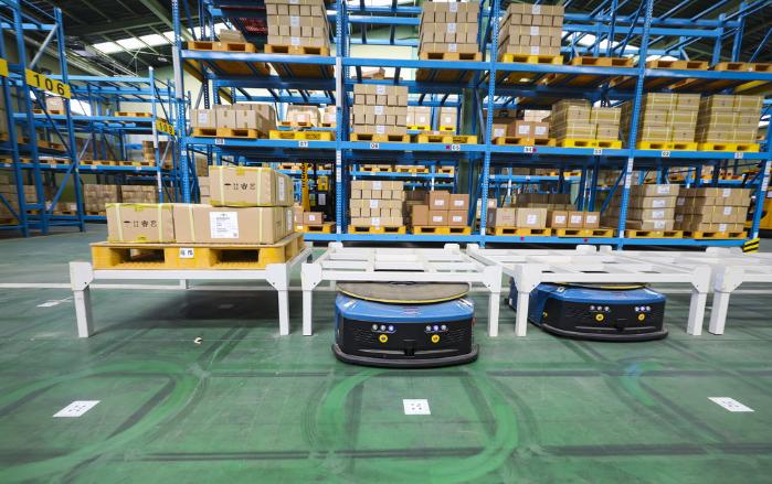 무인운반차가 작업자 앞으로 보급품을 전달하고 있다.