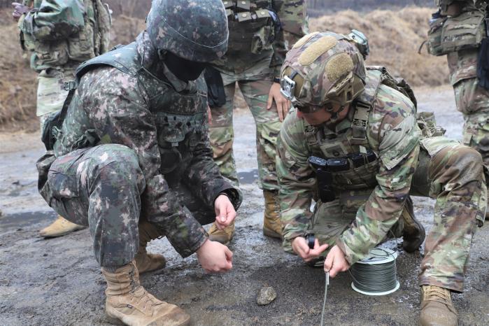 육군7공병여단 청호대대가 지난 6일부터 11일까지 경기 포천시 로드리게스 훈련장에서 실시한 한미 연합 장애물 개척훈련에서 양국 장병들이 급조식 파괴통 폭파를 위한 회로를 구성하고 있다. 부대 제공