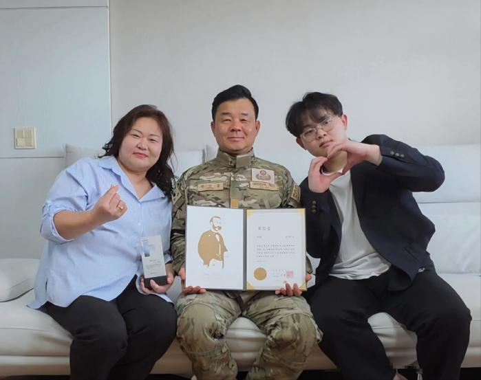해군군수사령부 병기탄약창 정경훈(가운데) 준위가 경남 창원시 진해구에 위치한 자택에서 헌혈유공장 명예장을 들고 가족들과 함께 기념촬영 하고 있다.