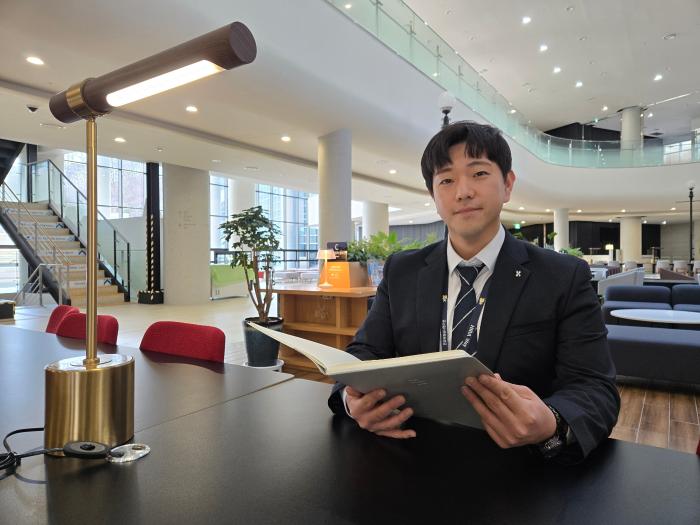 건강보험심사평가원에서 근무 중인 윤석영 예비역 육군대위가 책을 든 채 미소 짓고 있다. 보훈부 제공