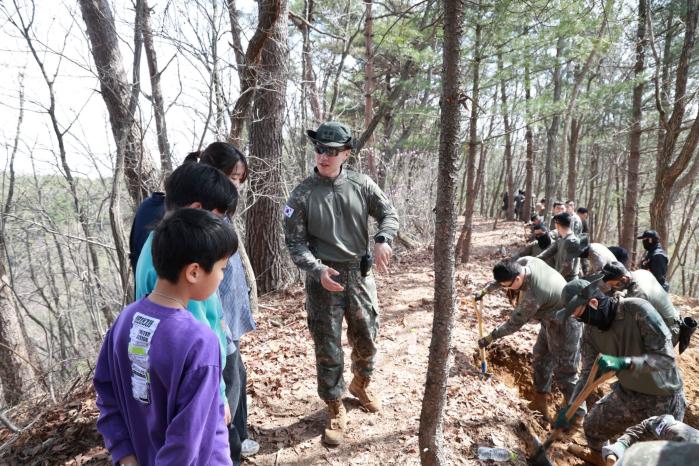 강원 횡성군 안흥초등학교 학생·교직원들이 14일 6·25전쟁 전사자 유해발굴 현장에서 발굴과정에 대한 설명을 듣고 있다. 부대 제공
