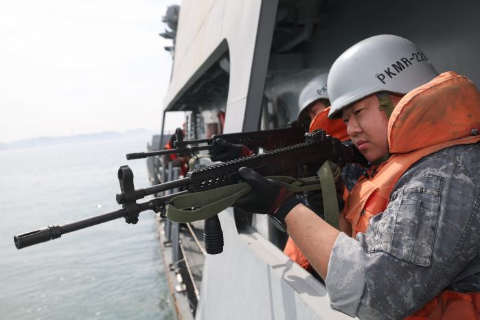 전투배치훈련의 하나로 소병기요원이 함정 현측에 배치돼 표적을 겨누고 있다.