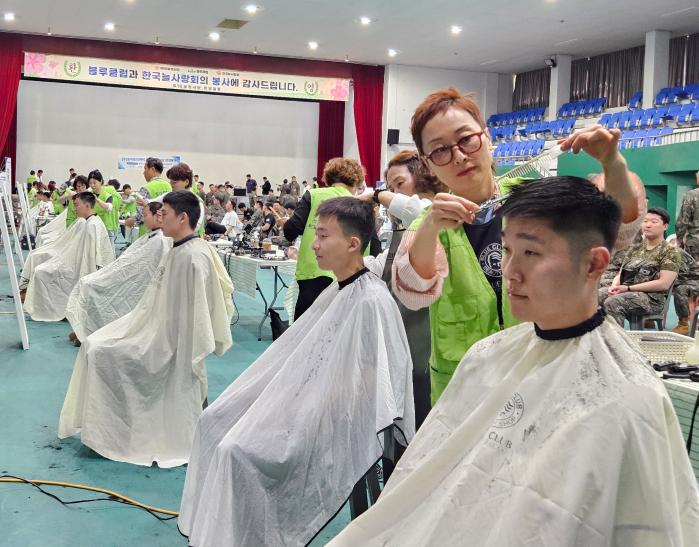 육군50보병사단이 21일 개최한 한국늘사랑회·블루클럽 초청 행사에서 봉사단원들이 장병들의 두발을 정리하고 있다. 부대 제공