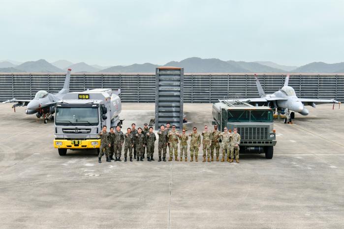 22일 한미연합 상호비상급유 훈련을 마친 공군1전투비행단과 광주기지 전개 미 공군 장병들이 항공기와 급유차량을 배경으로 기념촬영하고 있다. 사진 제공=윤민우 병장