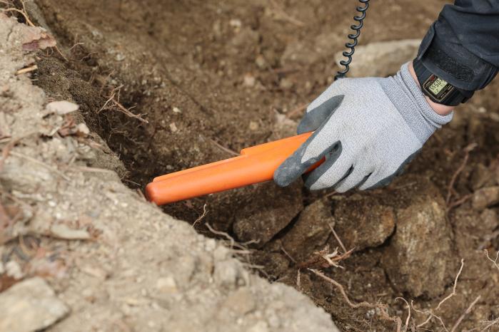 발굴 중 금속탐지기를 사용하는 모습.