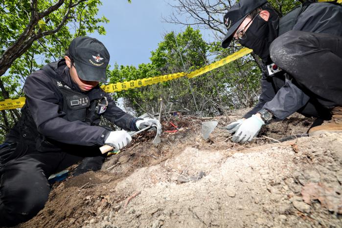 국방부유해발굴감식단 유해발굴기록병들이 21일 강원 홍천군 남면 금물산에서 전개된 유해발굴작전 중 도구를 이용해 유해 주위를 조심스럽게 발굴하고 있다. 조종원 기자