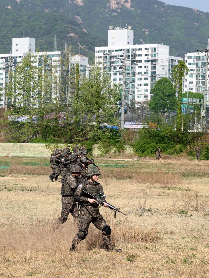 현역과 예비군이 함께 수풀을 탐색하며 거수자를 추적하고 있다.