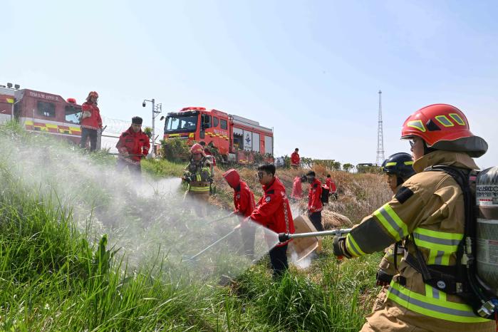해군3함대 해남통신지원대 장병들이 23일 부대 인근에서 실시한 합동 소화훈련에서 해남소방서 대원들과 함께 화재를 진압하고 있다. 사진 제공=오영택 하사