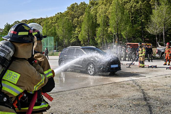 공군8전투비행단이 23일 개최한 ‘전기 화재 대비 안전교육’에서 공병대대 소방중대 장병들이 전기차 화재를 가정해 소화훈련을 하고 있다. 사진 제공=김민 하사