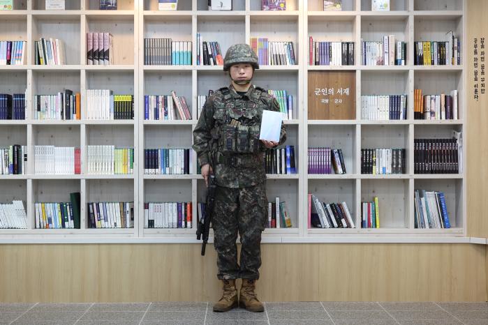 국방부가 병영독서 활성화를 위해 기획한 ‘한 손에 총, 한 손에 책(한 총, 한 책)’ 프로젝트가 본격 가동에 돌입한 가운데 육군52보병사단 박재홍 일병이 병영도서관에서 한 손에 총을, 한 손에 책을 들고 문무를 겸비한 ‘지혜로운 첨단강군’을 연출해 보이고 있다.