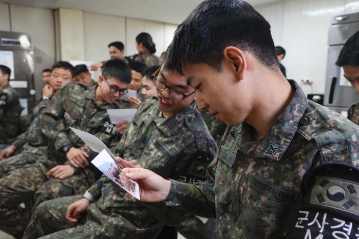 장병들이 밝은 표정으로 자신의 사진을 살펴보고 있다.
