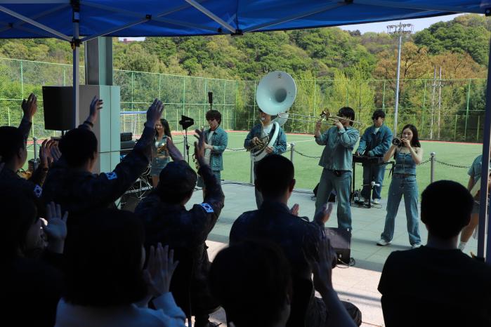육군1군수지원여단 장병들이 지난 24일 주둔지 연병장에서 국악브라스밴드 ‘시도’의 공연을 관람하고 있다. 부대 제공