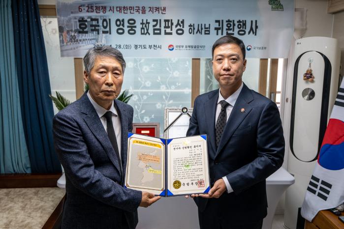 김성환(오른쪽) 국유단장이 28일 고 김판성 하사의 친조카 김창선 씨에게 전사자 신원확인 통지서를 전달하고 있다. 부대 제공