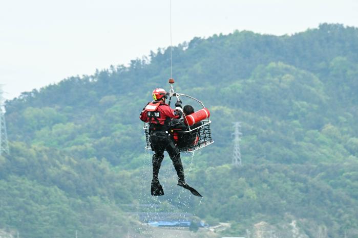 27일 해군3함대 인근 해상에서 진행된 ‘2026년 전반기 해군·해경 합동 항공구조 훈련’에서 구조대원들이 구조용 인양장치를 이용해 조난자 구조훈련을 하고 있다. 사진 제공=장효실 상사