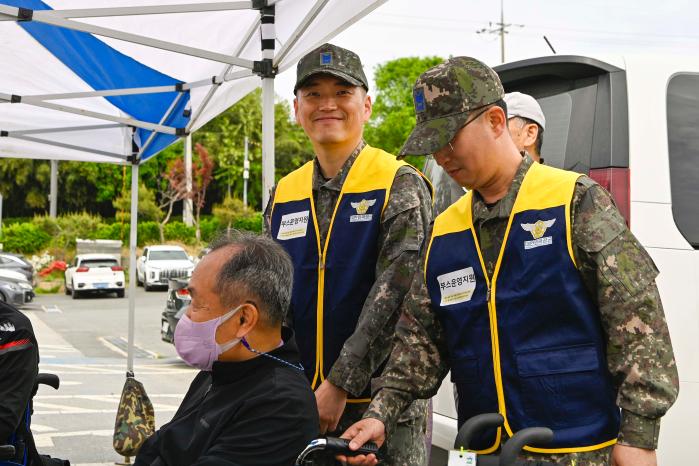 28일 공군1전투비행단 부사관단이 제20회 광산구 장애인 한마음대회에서 거동이 불편한 장애인들의 이동을 돕고 있다. 부대 제공