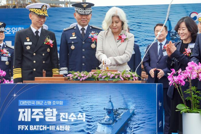 29일 열린 제주함 진수식에서 진영승 합참의장의 부인 정애숙(왼쪽 셋째) 여사가 진수줄을 절단하고 있다. 이경원 기자