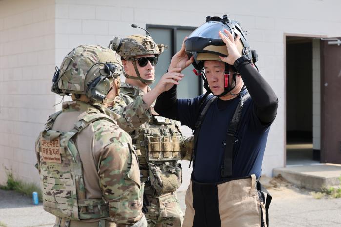 한미 공군 EOD 요원들이 서로의 장비와 복장을 챙겨주고 있다.