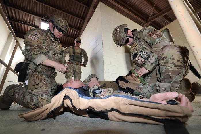 요원들이 부상당한 요원을 응급처치 하기 위해 방폭복을 해체하고 있다