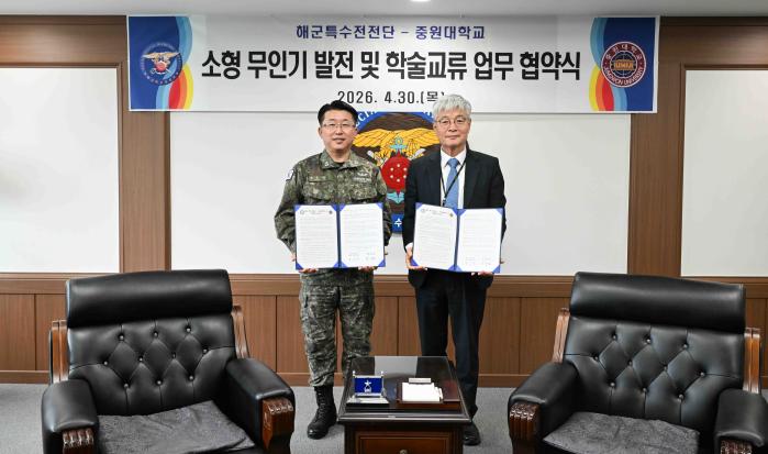 박순식(왼쪽) 해군특수전전단장과 장기원 중원대학교 총장이 소형 무인기 발전 및 학술교류를 위한 업무 협약식에서 협약서를 들고 있다. 부대 제공