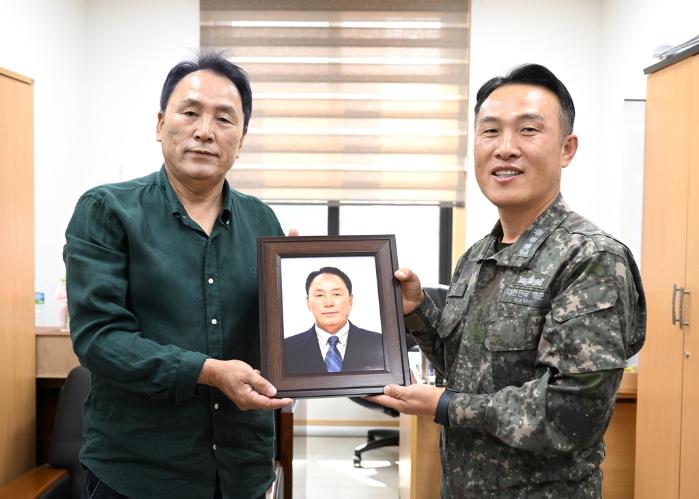 제주 강정마을 노인회관에서 김중구(오른쪽) 해군 기동함대참모장이 고영춘 노인회장에게 장수사진을 전달하고 있다. 사진제공=최호진상사