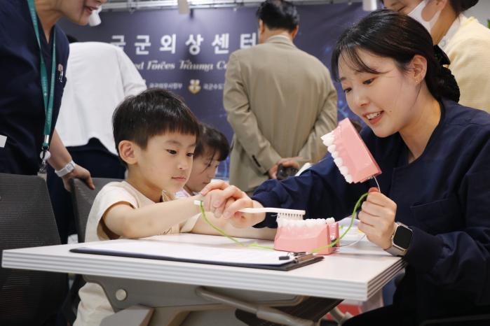 국군수도병원이 개최한 ‘사랑가득 가족 초청행사’에 참여한 어린이가 양치 교육 프로그램에 참여하고 있다.