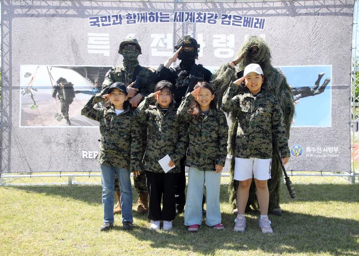 육군특수전사령부가 지난8일 개최한 군인가족·지역민 대상 부대개방 행사에서 어린이들이 저격복과 워리어플랫폼장비를 착용한 장병들과 함께기념사진을 찍고 있다. 부대제공