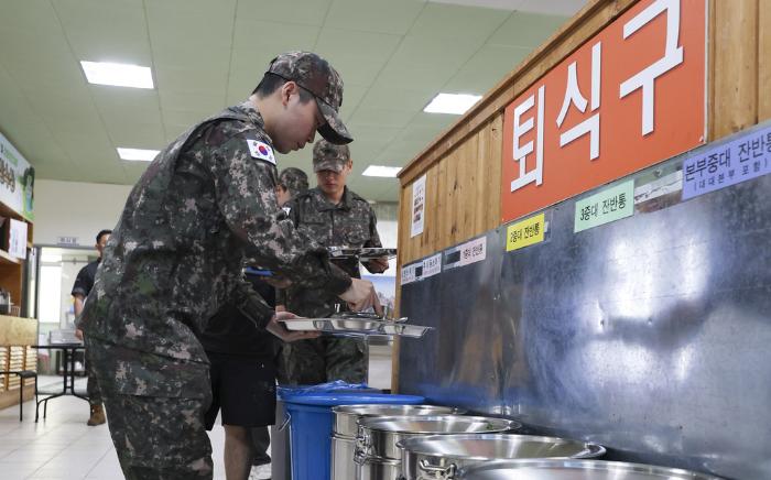 장병들이 식사 후 남은 음식물을 각 중대 처리 용기에 붓고 있다.