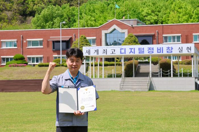 육군종합정비창 김홍기(군무사무관) 정보통신실장이 창원서부경찰서에서 받은 표창장을 들고 기념사진을 찍고 있다. 부대 제공