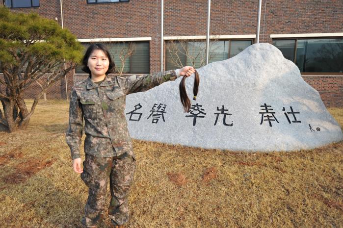 육군수사단 김혜인 중사가 어머나 운동본부에 기부한 머리카락을 들어 보이고 있다. 부대 제공