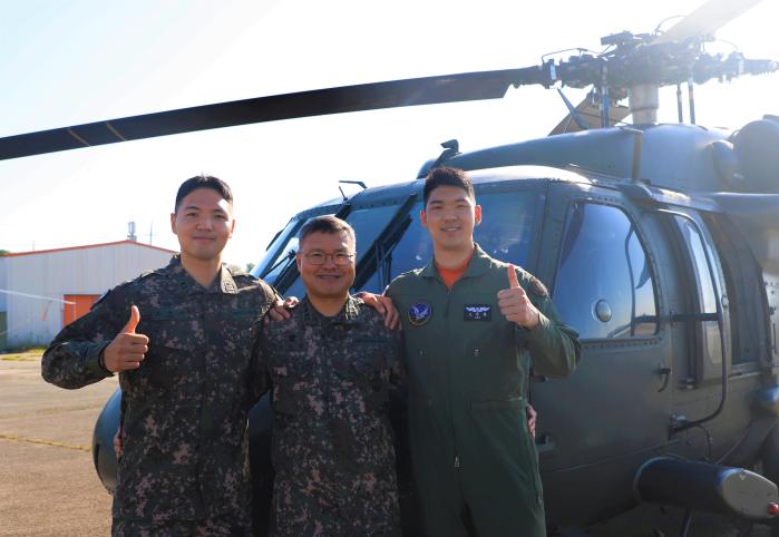 육군항공사령부 605항공대대 조승환(대위·진) 본부중대장과 아버지 조희정 대령, 동생 조정한 소위(오른쪽부터)가 UH-60 블랙호크 헬기 앞에서 포즈를 취하고 있다. 부대 제공