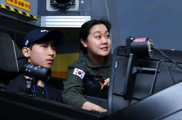 지난 15일 공군3훈련비행단 학생조종사가 한국항공우주소년단원에게 KT-1 항공기 시뮬레이터 작동법을 설명하고 있다. 사진 제공=김나영 하사