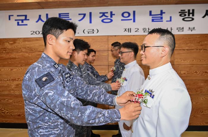 해군2함대가 지난 15일 개최한 군사특기장의 날 행사에서 후배 부사관들이 군사특기장에게 카네이션을 달아주고 있다. 사진 제공=박태환 병장