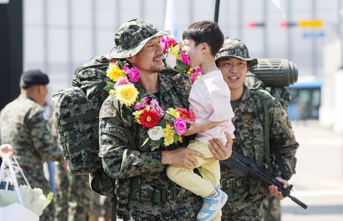 바라만 봐도 웃음이…육군특수전사령부 국제평화지원단 장병들이 26일에 걸쳐 진행된 내륙전술훈련을 마치고 전술행군을 통해 지난 15일 부대로 복귀했다. 부대는 이날 다양한 프로그램을 마련해 복귀한 장병들이 가족에게 고마운 마음을 표현할 수 있도록 했다. 박태준(중령) 독사대대장이 아들에게서 꽃목걸이를 받고 기뻐하는 모습. 김병문 기자