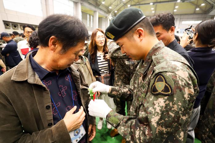 육군35보병사단이 20일 개최한 ‘신병 26-5기 수료식’에서 신진욱 이병이 아버지 가슴에 카네이션을 달아드리고 있다. 부대 제공