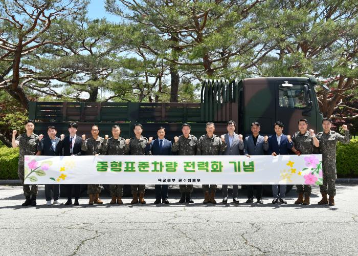 육군이 지난 22일 계룡대에서 개최한 중형표준차량 전력화 기념행사에서 하헌철(오른쪽 일곱째) 군수참모부장과 전력화 유공 수상자 등이 기념촬영을 하고 있다. 육군 제공