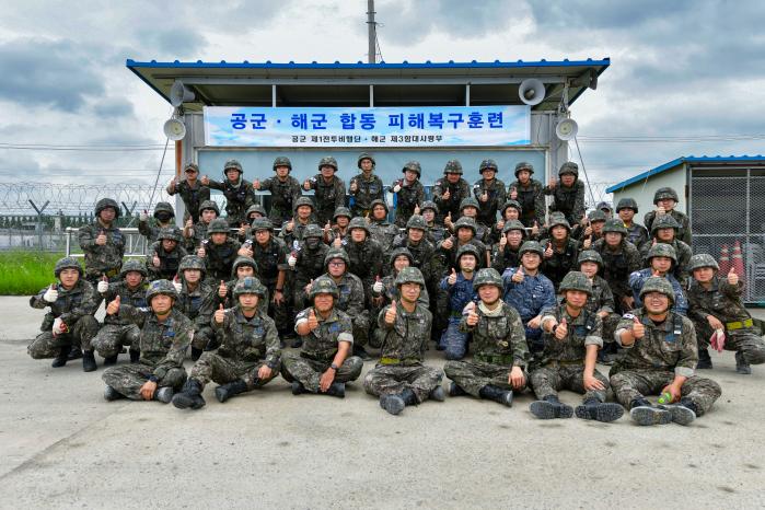 27일 공군1전투비행단과 해군3함대 공병대대 장병들이 합동 피해복구훈련을 마친 뒤 기념촬영을 하고 있다. 사진 제공=김시현 하사