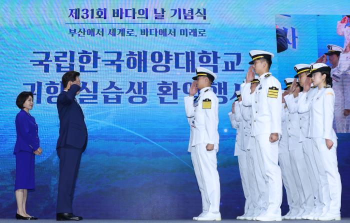 이재명 대통령이 27일 부산시 한국해양대에서 열린 제31회 바다의 날 기념식에서 해양대 실습생의 귀항 보고를 받고 있다. 연합뉴스