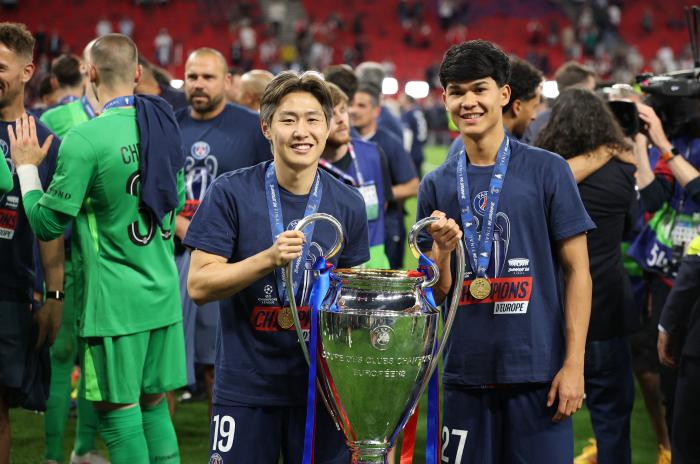 PSG 이강인(왼쪽)이 31일(한국시간) UCL 결승전이 끝난 뒤 우승 트로피를 들고 포즈를 취하고 있다. 로이터·연합뉴스