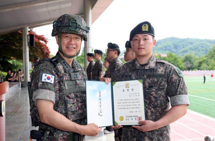 어창준(왼쪽) 수도방위사령관이 휴가 중 음주운전자 검거에 일조한 김동환 상병에게 방패전사상을 수여한 후 기념촬영하고 있다. 부대 제공