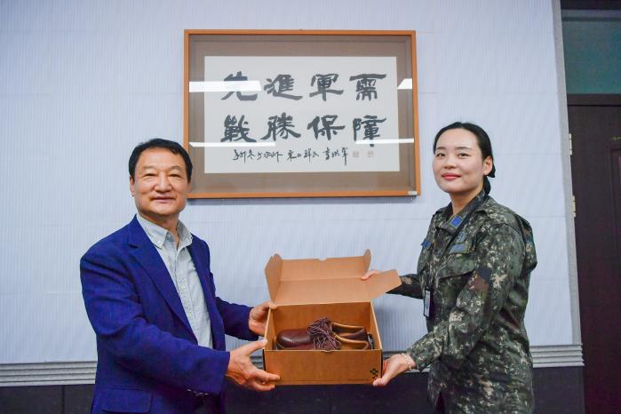 공군군수사령부 김미지(오른쪽) 상사가 부대원들을 대표해 백호정 선형상사 대표로부터 맞춤형 신발을 받고 있다. 부대 제공